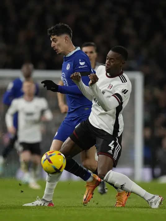 Gelandang Chelsea Kai Havertz dan bek Fulham Tosin Adarabioyo berebut bola pada laga tunda pekan ke-7 Premier League 2022/2023 di Craven Cottage, Jumat (13/1/2023) WIB. Dua gol Fulham dicetak masing-masing oleh Willian (25’) dan Vinicius (73’). (AP Photo/Alastair Grant)