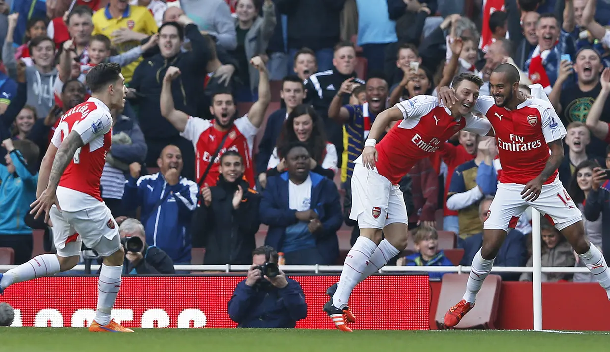 Pemain Arsenal Mesut Ozil merayakan gol bersama rekannya Theo Walcott pada Laga lanjutan Liga Premier Inggris antara Arsenal vs Manchester United di Emirates Stadium. Minggu (04/10/2015). Arsenal menang 3-0. (Action Images via Reuters / Carl Recine)