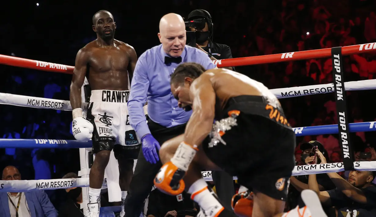 Terence Crawford (kiri) menjatuhkan Shawn Porter pada pertandingan tinju perebutan gelar juara dunia kelas welter WBO di Las Vegas, Amerika Serikat, 20 November 2021. Terence Crawford menang TKO pada ronde 10. (AP Photo/Chase Stevens)