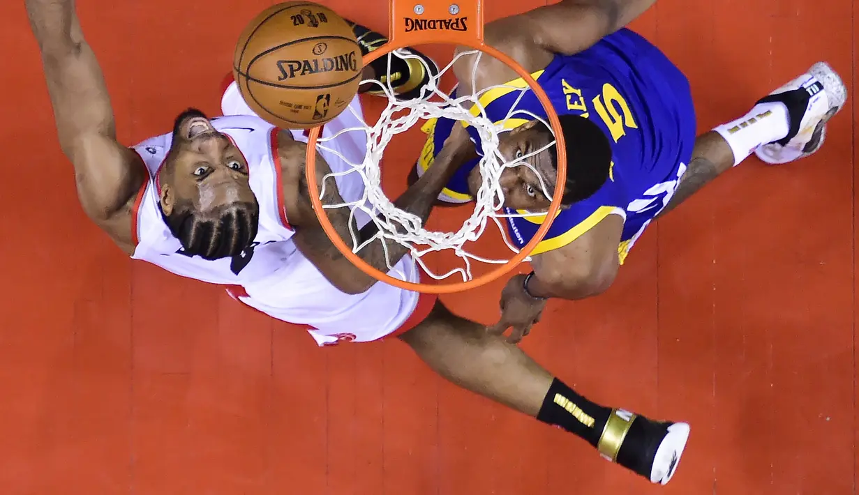 Pebasket Toronto Raptors, Kawhi Leonard, berebut bola dengan pebasket Golden State Warriors, Kevon Looney, pada laga Final NBA di Scotiabank Arena, Toronto, Kamis (30/5). Raptors menang 118-109 atas Warriors. (AP/Nathan Denette)