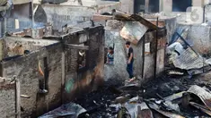 Warga mencari barang-barang dari bangunan pascakebakaran yang melanda kawasan pemukiman di Jalan Manggarai Utara, Jakarta, Kamis (14/12/2023). (Liputan6.com/Herman Zakharia)