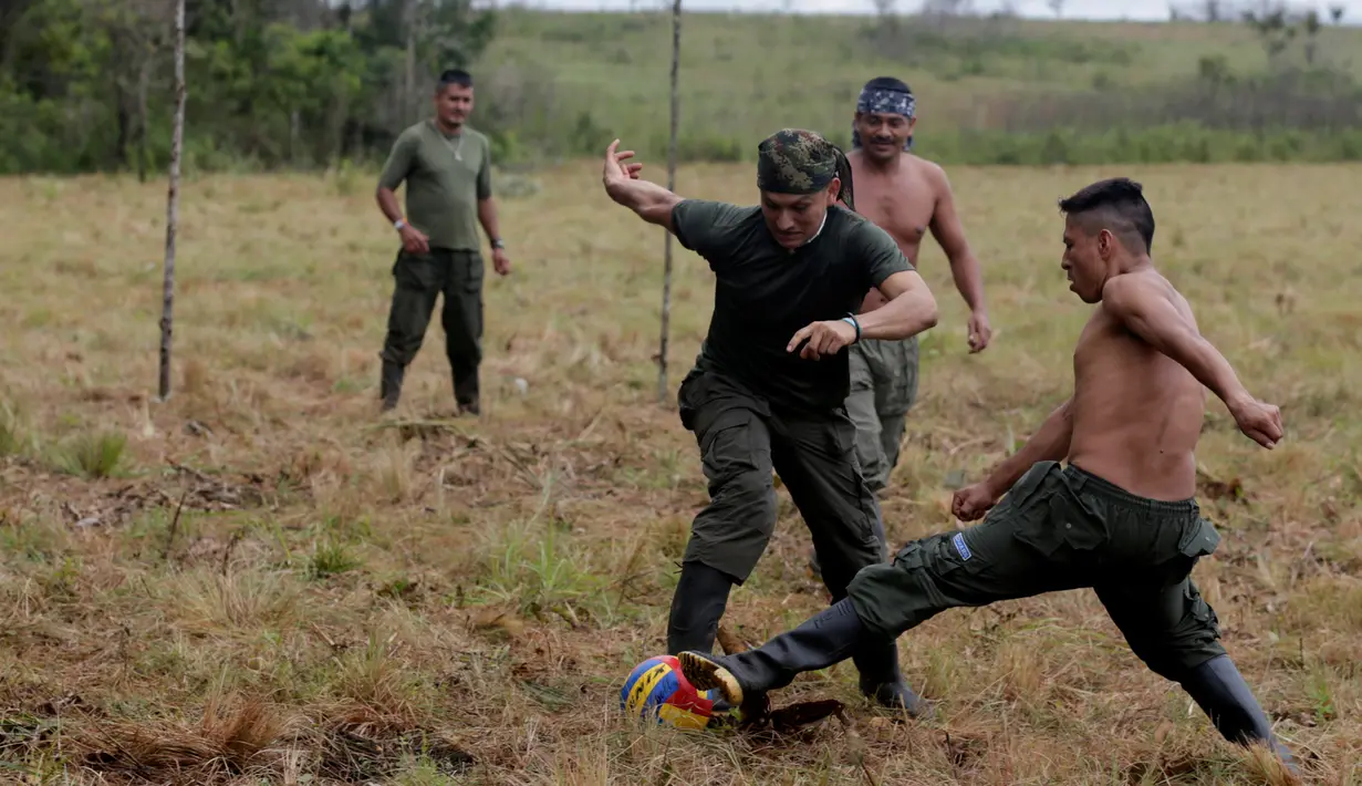 Pejuang dari Angkatan Bersenjata Revolusioner Kolombia (FARC) bermain sepak bola di sebuah kamp di mana mereka mempersiapkan diri untuk meratifikasi kesepakatan damai dengan pemerintah, di Yari Plains, Kolombia, (19/9). (REUTERS/John Vizcaino)