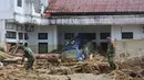 Tumpukan-tumpukan kayu gelondongan ini merupakan material yang terbawa arus banjir bandang yang terjadi Selasa (25/11/2025) lalu. Tampak dalam foto, personel Tentara Nasional Indonesia (TNI) mencari korban banjir di Batang Toru, Sumatra Utara, Selasa 2 Desember 2025. (AP Photo/Binsar Bakkara)
