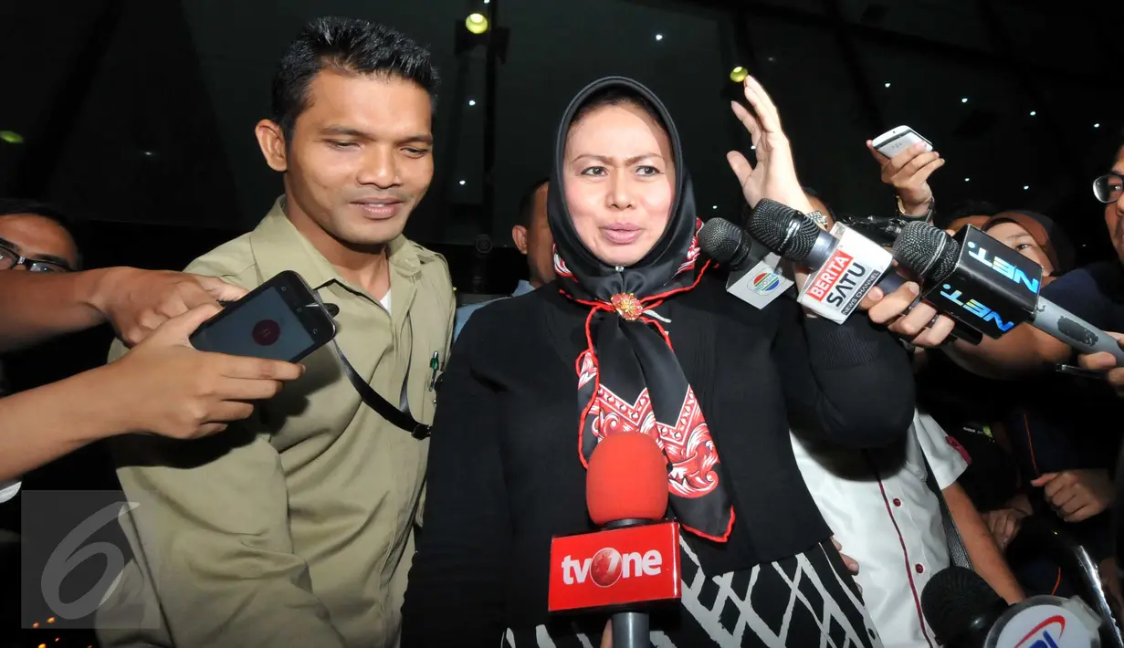 Istri Pelaksana Tugas (Plt) Gubernur Sumatera Utara Tengku Erry Nuradi, Evi Diana, menghindar dari wartawan usai diperiksa KPK, Jakarta, Kamis (5/11/15). Evi yang diperiksa sebagai saksi untuk Gatot Pujo Nugroho. (Liputan6.com/Helmi Afandi) 