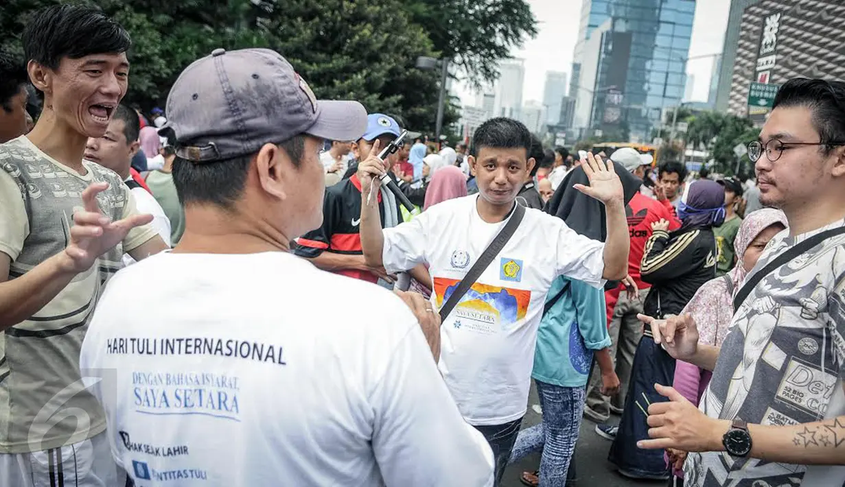 Penyandang disabilitas tuna rungu dan tuna wicara berkumpul memperingati Hari Tuli Internasional di arena Car Free Day, Jakarta, Minggu (25/9). Dalam kampanye ini, mereka memperagakan bahasa isyarat kepada warga masyarakat. (Liputan6.com/Faizal Fanani)
