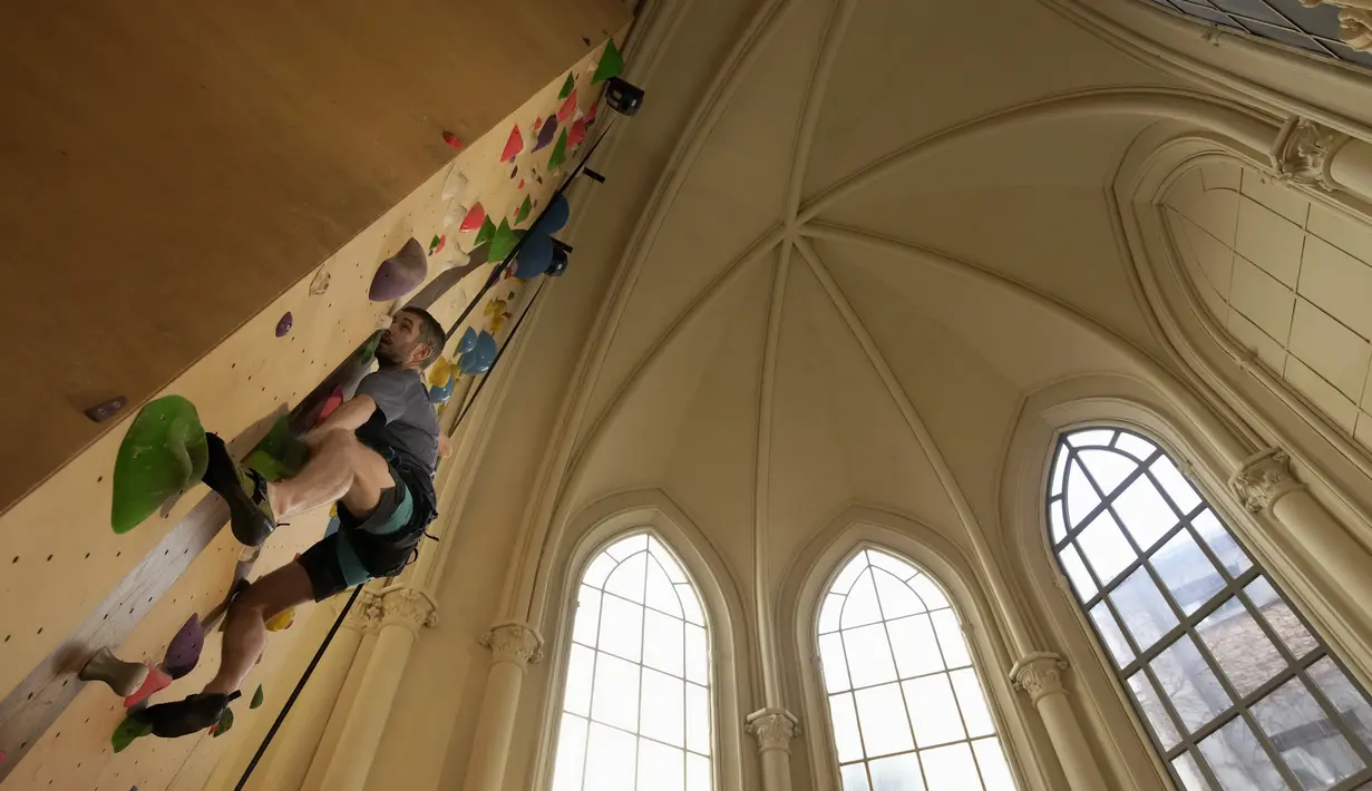 Seorang peserta berlatih memanjat di lokasi Climbing District di Paris, Rabu, 11 Januari 2023. Tembok panjat buatan baru ini dibuka pada November 2022 di dalam bekas kapel abad ke-19, bernama le couvent des Oblats de Marie-Immaculee. (AP Photo/Christophe Ena)