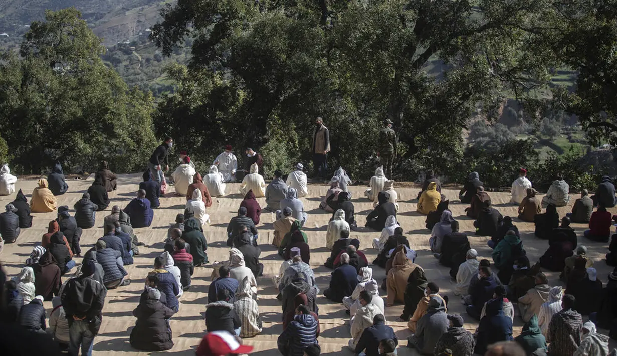 Orang-orang menjaga jarak sosial saat berdoa pada pemakaman Rayan Oram (5) di Desa Ighran, Provinsi Chefchaouen, Maroko, 7 Februari 2022. Rayan Oram meninggal setelah terjebak selama lima hari dalam sumur kering sedalam 32 meter. (AP Photo/Mosa'ab Elshamy)
