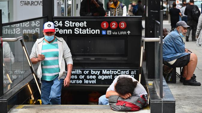 Seseorang tidur di tangga kereta bawah tanah dekat Penn Station di New York City pada Kamis (17/9/2020). Sejak pandemi virus corona, para tunawisma kini lebih terlihat seiring banyaknya penutupan banyak tempat penampungan karena alasan kesehatan. (Angela Weiss / AFP)