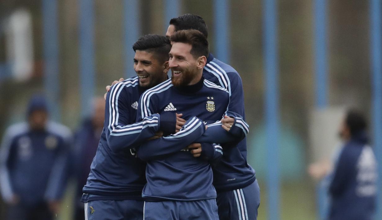 Ever Banega (kiri) memeluk Lionel Messi dan Angel Di Maria pada sesi latihan jelang melawan Venezuela pada kualifikasi Piala Dunia 2018 di Buenos Aires, Argentina, (3/9/2017). (AP/Natacha Pisarenko)