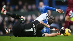 Kiper Aston Villa, Emiliano Martinez (kiri) berebut bola dengan pemain Everton, Amadou Onana pada laga lanjutan Liga Inggris 2023/2024 di Goodison Park, Liverpool, Inggris, Minggu (14/01/2024) malam WIB. (AFP/Paul Ellis)