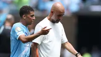 Bek Manchester City, Rico Lewis (kiri), bicara dengan pelatihnya, Pep Guardiola, saat jeda antar babak pertandingan melawan Wydad AC di Piala Dunia Antarklub 2025, Kamis (19/6/2025) dini hari WIB. (CHARLY TRIBALLEAU / AFP)