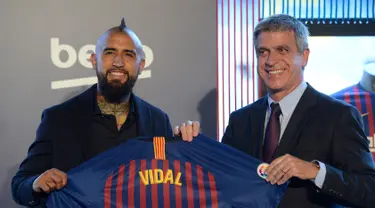 Pemain baru Barcelona, Arturo Vidal (kiri) berpose dengan Wakil Presiden Barcelona Jordi Mestre dalam presentasi resminya di Stadion Camp Nou, Barcelona, Spanyol, Senin (6/8). (Josep LAGO/AFP)