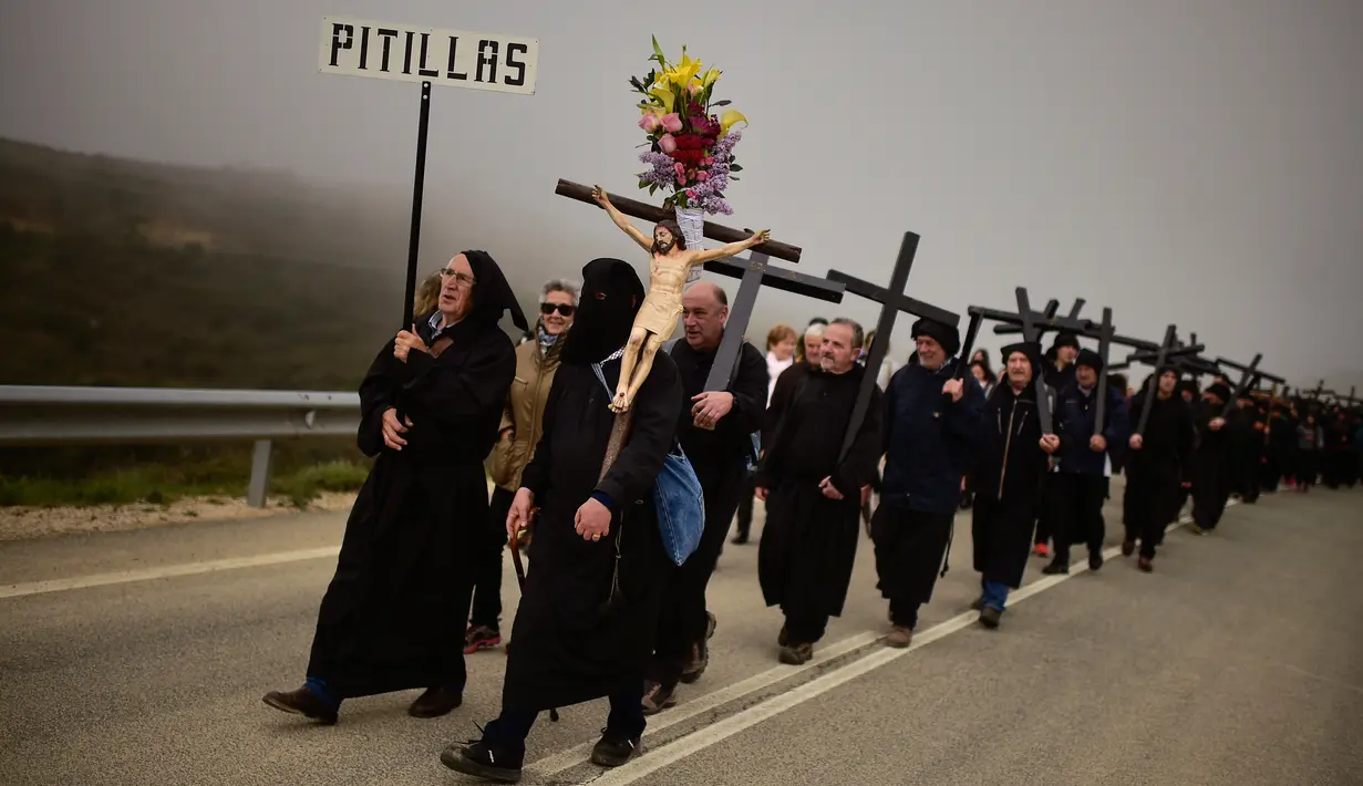 Jemaat katolik Ujue Virgin berbaris membawa salib saat melakukan ziarah dari Tafalla dan desa-desa lainnya ke kota kecil Ujue, Spanyol Utara (29/4). Mereka berjalan sekitar 25 km (16 mil) dari desa mereka menuju Ujue. (AP/Alvaro Barrientos)