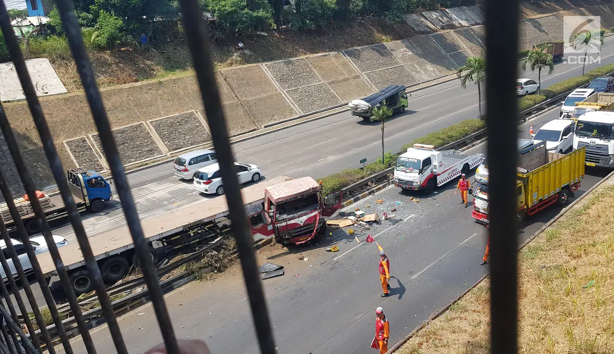 Petugas mengatur arus lalu lintas usai terjadi kecelakaan truk trailer dengan minibus di Tol JORR TB Simatupang Km 29, Jakarta, Jumat (30/8/2019). Kecelakaan tersebut menyebabkan kemacetan panjang. (Liputan6.com/Herman Zakharia)