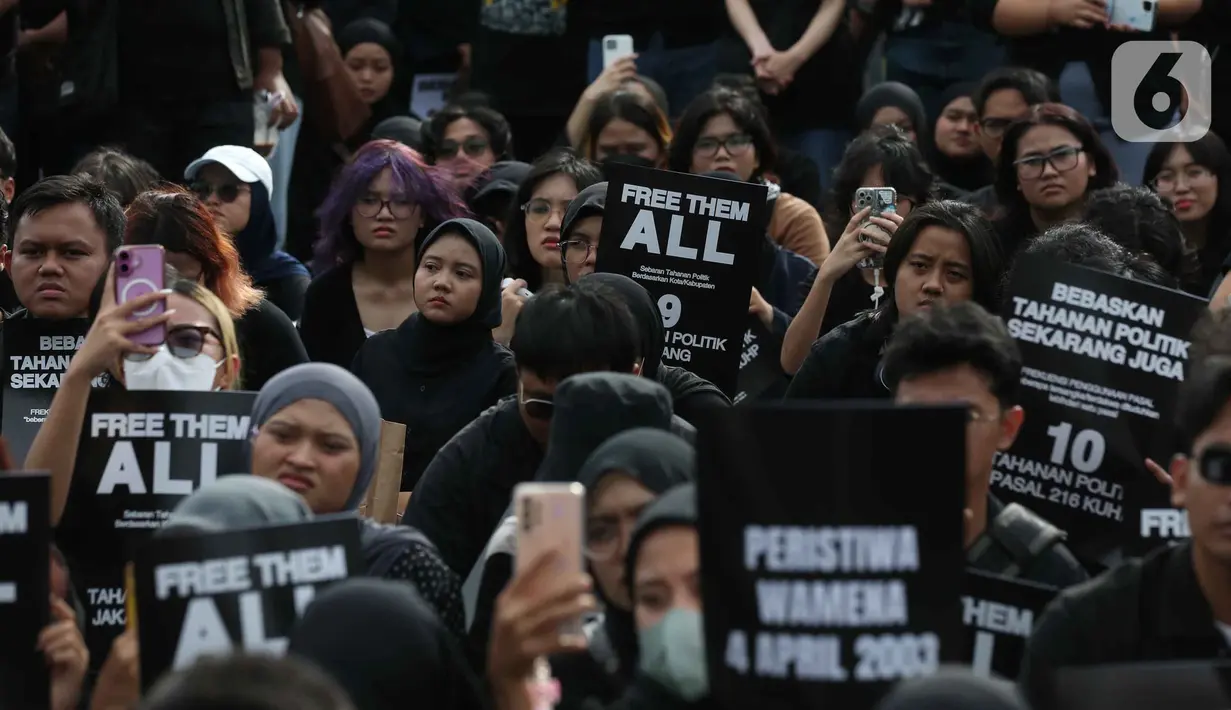 Aksi ini dikenal dengan penggunaan pakaian dan payung berwarna hitam sebagai simbol keteguhan hati dalam mencari keadilan serta duka yang tak kunjung padam karena belum tuntasnya kasus pelanggaran HAM berat di Indonesia. Tampak dalam foto, aktivis Jaringan Solidaritas Korban untuk Keadilan memegang pamflet saat mengikuti peringatan 19 tahun Aksi Kamisan di Jalan Medan Merdeka Utara atau di seberang Istana Merdeka, Jakarta, 15 Januari 2026. (Liputan6.com/Helmi Fithriansyah)