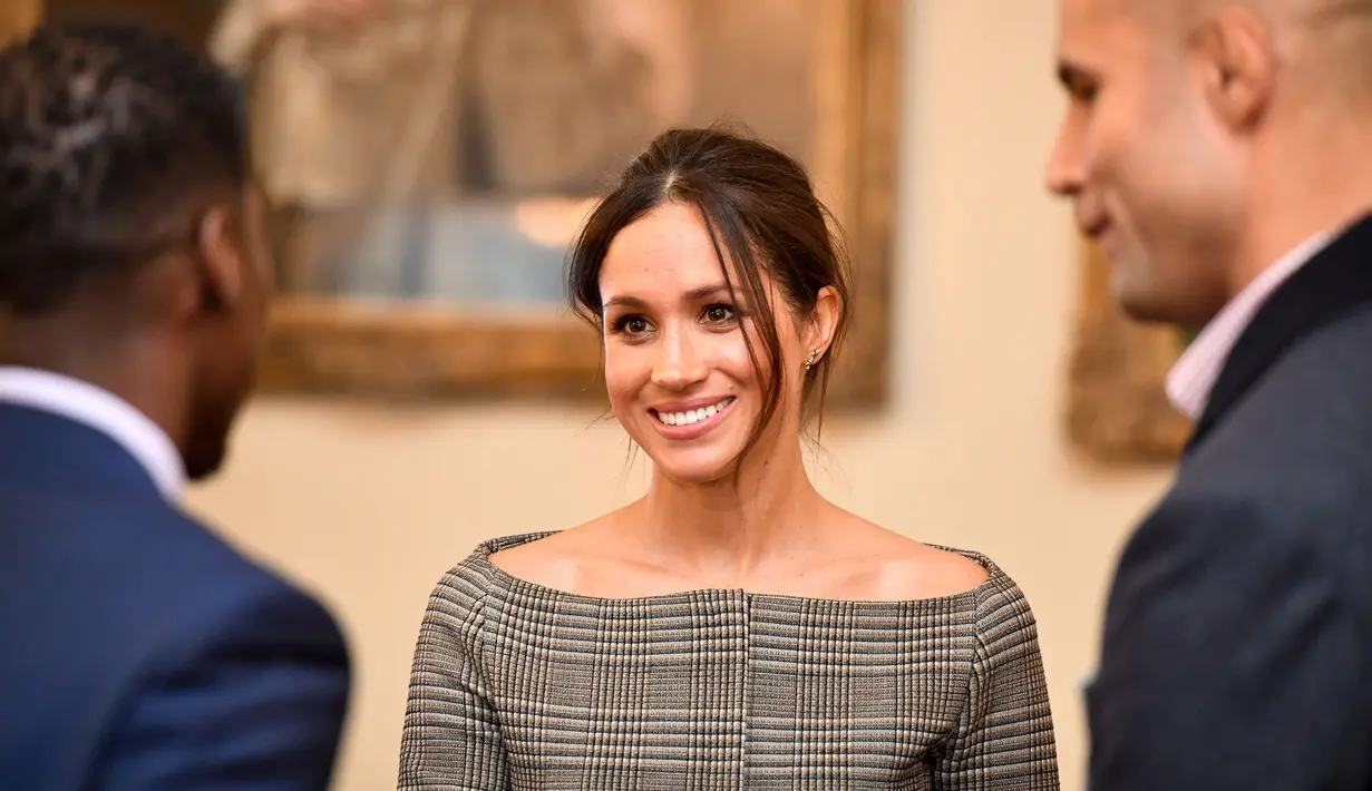 Tunangan Pangeran Harry dari Inggris, Meghan Markle berbincang saat mengunjungi Cardiff Castle di Wales, Kamis (18/1). Usut punya usut, kunjungan Harry dan sang tunangan dilakukan untuk mendekatkan Meghan kepada kebudayaan Inggris. (BEN BIRCHALL/POOL/AFP)