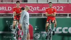 Pelatih Maroko, Walid Reragui (tengah) berbicara dengan bek Achraf Hakimi (kanan) dan Nayef Aguerd selama sesi latihan di Stadion Al Duhail SC di Doha (16/12/2022). Maroko akan bertanding melawan Kroasia untuk memperebutkan juara 3 Piala Dunia 2022. Keduanya dipertemukan kembali setelah pernah bertanding pada babak penyisihan grup F lalu. (AFP/Karim Jafaar)