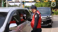 Petugas mengecek suhu tubuh penumpang di Rest Area KM 13,5 Palm Square Tol Jakarta-Tangerang, Jumat (29/5/2020). Penerepan parkir berjarak dan pengecekan suhu tubuh di area tersebut diberlakukan untuk menekan penyebaran Covid-19. (Liputan6.com/Angga Yuniar)