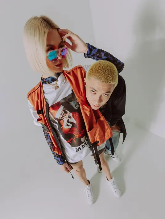 Agnez yang dikenal menyukai gaya eksentrik juga terlihat menumpuk kaus putih dengan kaus lengan panjang animal print dan vest warna orange (Foto: Instagram @anyemerch)