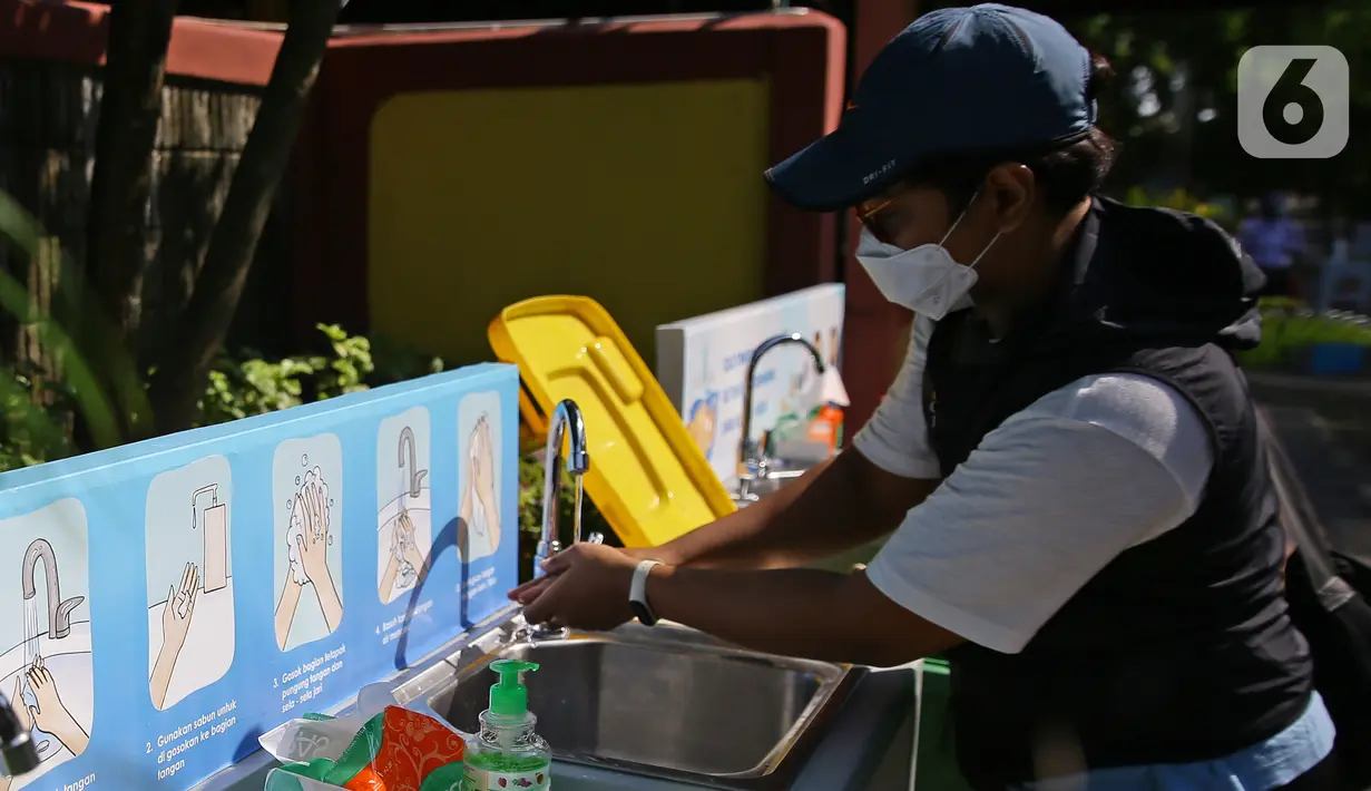 Pengunjung mencuci tangan memasuki Taman Margasatwa Ragunan, Jakarta, Sabtu (20/6/2020). Ragunan mulai dibuka kembali untuk pengunjung pada Sabtu ini di masa PSBB transisi dengan pembatasan dan penerapan protokol kesehatan yang ketat. (Liputan6.com/Herman Zakharia)