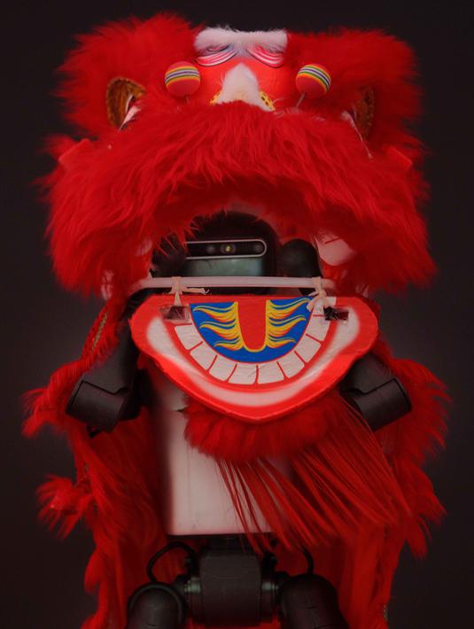 Robot-robot tersebut juga dirancang untuk tampil dengan beragam elemen budaya, seperti mengenakan atribut tradisional atau melakukan gerakan yang menyerupai tarian naga dan barongsai. Tampak dalam foto, sebuah robot humanoid dengan kostum barongsai tampil di atas panggung selama pratinjau media sebuah festival kuil robot menjelang Tahun Baru Imlek di Beijing, China, Jumat 13 Februari 2026. (AP Photo/Vincent Thian)