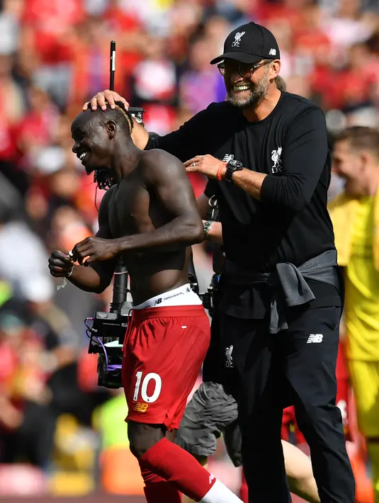 Manajer Liverpool Jurgen Klopp (kanan) memegang kepala Sadio Mane usai tim asuhannya mengalahkan Newcastle United pada laga Liga Inggris di Anfield, Liverpool, Inggris, Sabtu (14/9/2019). Sadio Mane dan Mohamed Salah membawa Liverpool menghajar Newcastle 3-1. (Paul ELLIS/AFP)