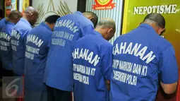 Para tersangka dihadirkan saat rilis barang bukti di Mako Ditnarkoba Mabes Polri, Jakarta, Jumat (19/2). Petugas menangkap 7 orang tersangka sindikat narkotika internasional dan menyita 40 ribu butir ekstasi senilai Rp24 M. (Liputan6.com/Yoppy Renato)