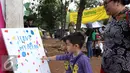 Orang tua menyaksikan anakanya melukis dalam festival laut 2015 di taman Kridaloka,  Senayan, Jakarta, Sabtu (19/9/2015). Festival bertujuan untuk mengenalkan dunia laut Indonesia kepada masyarakat serta untuk menjaganya. (Liputan6.com/Angga Yuniar)