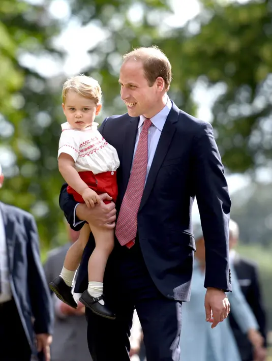 Pangeran William tampak menggendong Pangeran George usai upacara pembaptisan Putri Charlotte di Gereja St. Mary Magdalene, Sandringham, Inggris, Minggu (5/7/2015). (REUTERS/Chris Jackson/Pool)