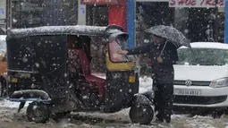 Seorang pria Kashmir membersihkan salju dari bajajnya di Srinagar, Kashmir yang dikuasai India (15/1/2020). Menurut pejabat sipil Baseer Khan, Jalur listrik rusak dan banyak jalan terkubur di bawah salju yang mempengaruhi aktivitas warga sehari-hari. (AP Photo/Dar Yasin)
