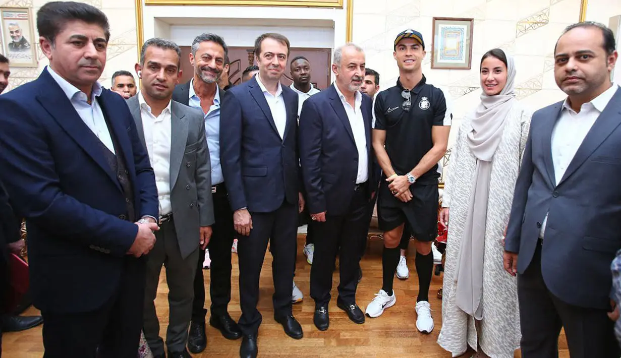 Pemain Al-Nassr, Cristiano Ronaldo (ketiga kanan) berfoto bersama dengan ofisial setibanya di Imam Khomeini International Airport, Tehran menjelang laga Liga Champions Asia 2023 melawan Persepolis FC, Selasa (19/09/2023). (AFP/Persepolis FC)