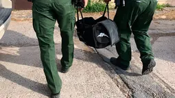 Agen patroli perbatasan Amerika Serikat membawa anak harimau di sebuah tas, yang disita di perbatasan Texas, menuju Kebun Binatang Gladys Porter, Brownsville, 30 April 2018. Anak harimau jantan itu ditemukan dalam keadaan tidak sadar di tas ransel. (AP)