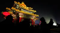 Siluet pengunjung terlihat ketika mengunjungi Kota Terlarang atau Forbidden City  yang diterangi pertunjukan cahaya selama perayaan Festival Lentera di Beijing, Selasa (19/2). Festival itu menandai berakhirnya liburan Tahun Baru Imlek (AP/Andy Wong)