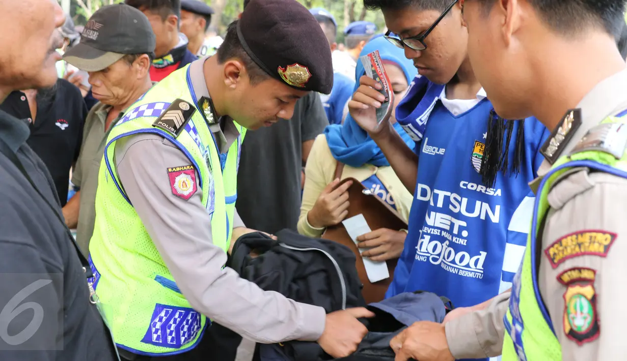 Polisi memeriksa tas yang dibawa oleh para Bobotoh saat memasuki kawasan SUGBK, Jakarta, Minggu (18/10/2015). Kedatangan Bobotoh untuk mendukung Persib Bandung melawan Sriwijaya FC di Final Piala Presiden 2015 (Liputan6.com/Herman Zakharia)