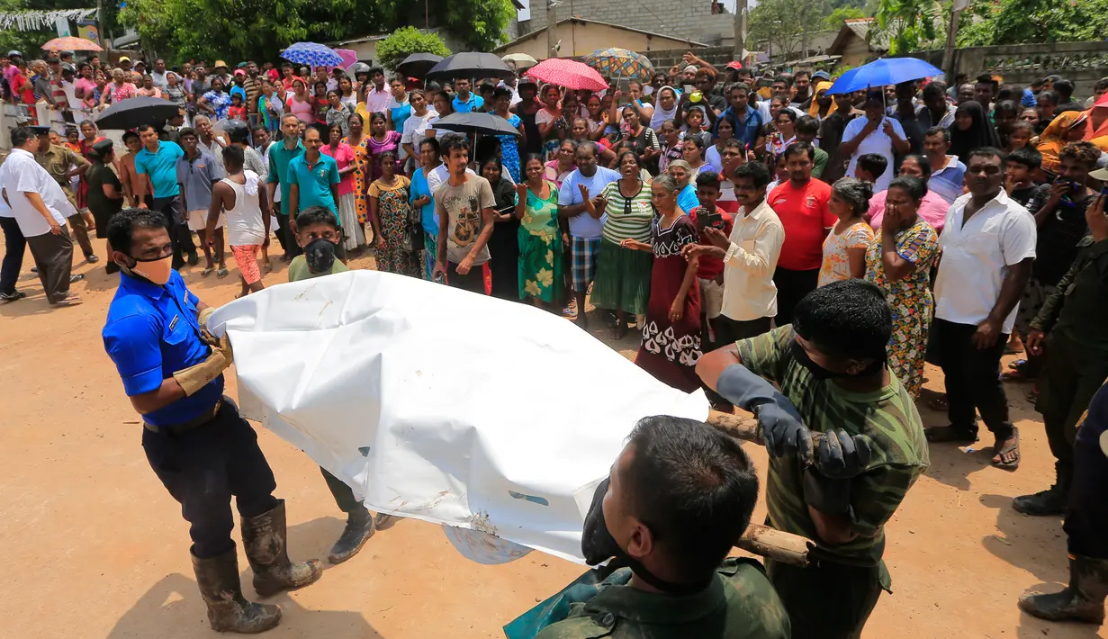 Anggota militer Sri Lanka mengangkut jenazah korban tewas akibat tertimbun sampah longsor di Meetotamulla, dekat ibukota Kolombo, Minggu (16/4). Timbunan sampah mencapai 91 meter menghantam ratusan rumah warga di bawahnya. (AP Photo/Eranga Jayawardena)