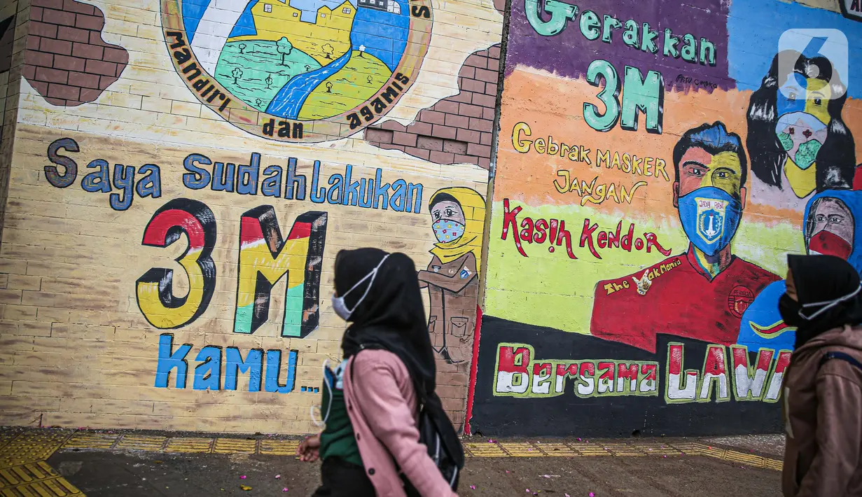 Pejalan kaki melintas dekat lukisan mural melawan COVID-19 di Kawasan Cikokol, Cawang, Jakarta, Minggu (4/10/2020).  Mural masih dianggap menjadi sarana edukasi kesehatan yang tepat bagi warga untuk menjaga diri dari penularan virus Covid 19. (Liputan6.com/Faizal Fanani)