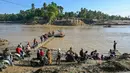 Sejumlah warga menunggu waktu naik rakit tali untuk menyeberangi Sungai Peusangan menyusul banjir bandang yang menghancurkan desa-desa di sekitarnya di Kabupaten Bireuen, provinsi Aceh, pada Senin 5 Januari 2026. Sebulan lebih pasca terjangan banjir bandang, warga di sekitar Sungai Peusangan Bireuen Aceh masih menggunakan metode penyeberangan darurat. (CHAIDEER MAHYUDDIN/AFP)