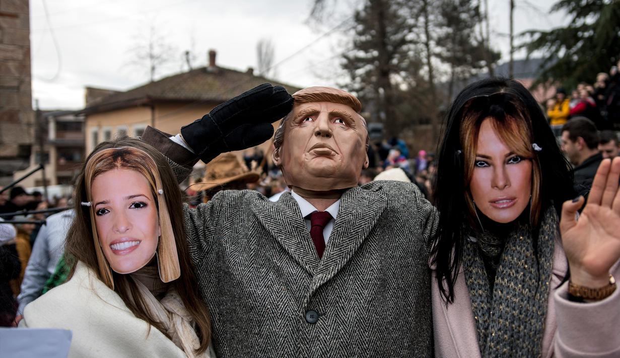 Peserta berpakaian seperti Ivanka Trump, Presiden AS Donald Trump dan Melania Trump saat mengikuti karnaval di desa Vevcani, Macedonia (13/1). Karnaval Vevcani ini selalu digelar setiap tahunnya dan telah berusia 1,400 tahun.(AFP Photo/Robert Atanasovski)