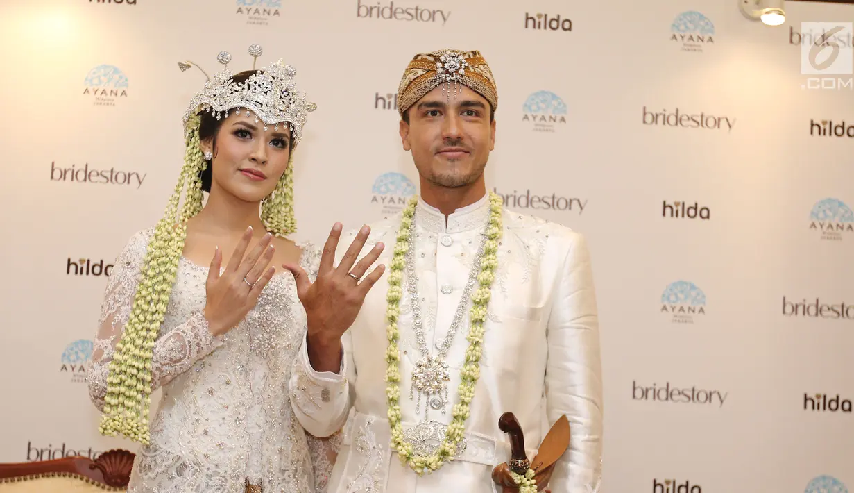 Pasangan Raisa Andriana dan Hamish Daud Wyllie menunjukkan cincin pernikahan usai jumpa pers di Ayana MidPlaza, Jakarta, Minggu (3/9). Raisa dan Hamish resmi menjadi pasangan suami istri pada 3 september 2017. (Liputan6.com/Herman Zakharia)
