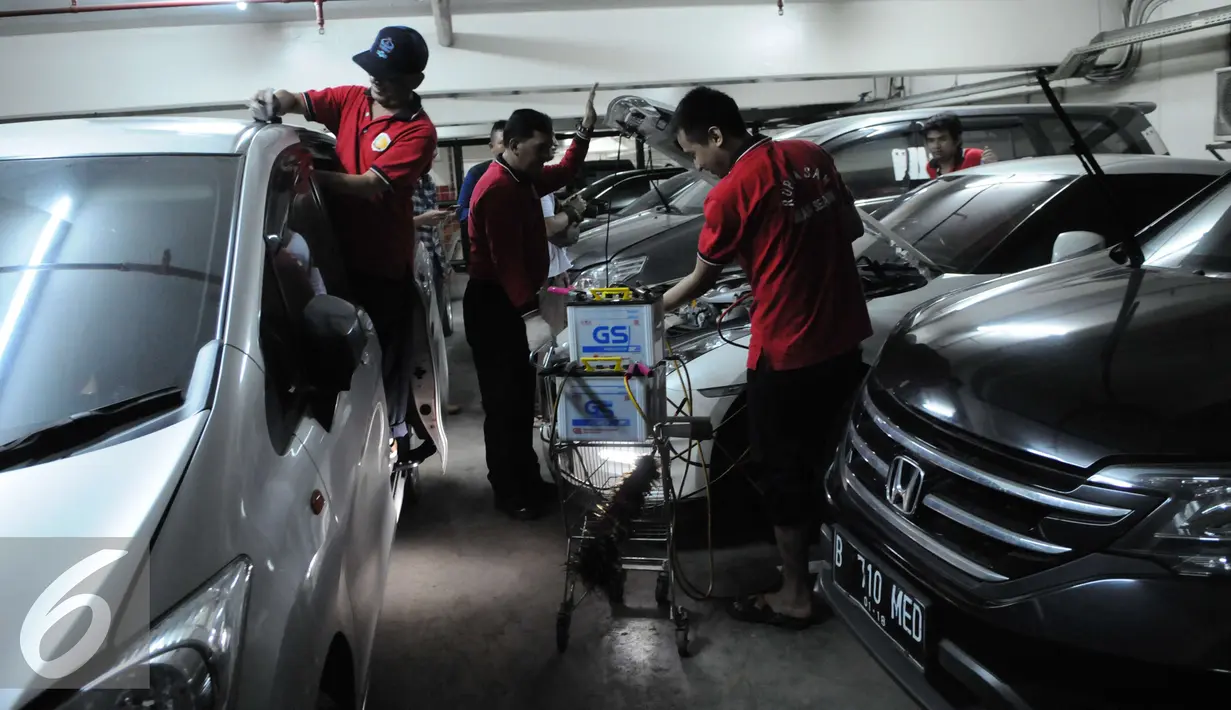 Petugas merawat mobil hasil sitaan para tersangka kasus korupsi di Rumah Penyimpanan Benda Sitaan Negara (Rupbasan), Jakarta, Selasa (6/12). Anggaran untuk perawatan Rupbasan yang saat ini teralokasi 20 juta pertahun. (Liputan6.com/Helmi Affandi)
