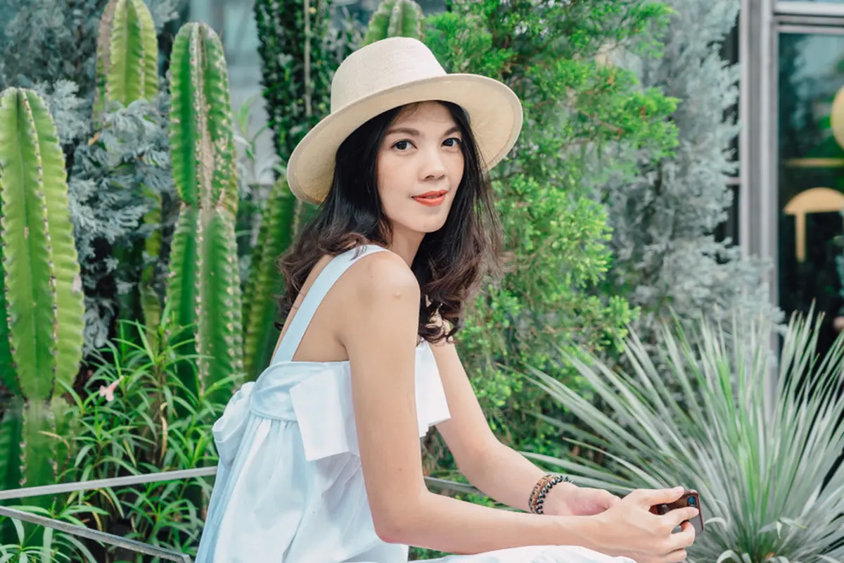tersenyum dewasa santai topi di taman