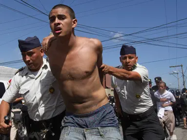 Petugas polisi membawa narapidana yang ditangkap dari penjara Juvenile Gaviotas di Guatemala City, Guatemala (3/7). Kerusuhan di penjara tersebut terjadi usai dua narapidana ditemukan tewas tergantung. (AP Photo / Moises Castillo)