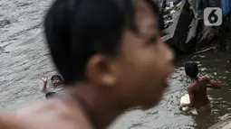 Anak-anak berenang di Sungai Ciliwung, Jakarta, Selasa (24/8/2021). Sungai Ciliwung menjadi tempat alternatif untuk bermain di kala pandemi karena ditutupnya ruang-ruang bermain atau taman kota, dan juga karena kurangnya ruang bermain bagi anak-anak. (Liputan6.com/Johan Tallo)