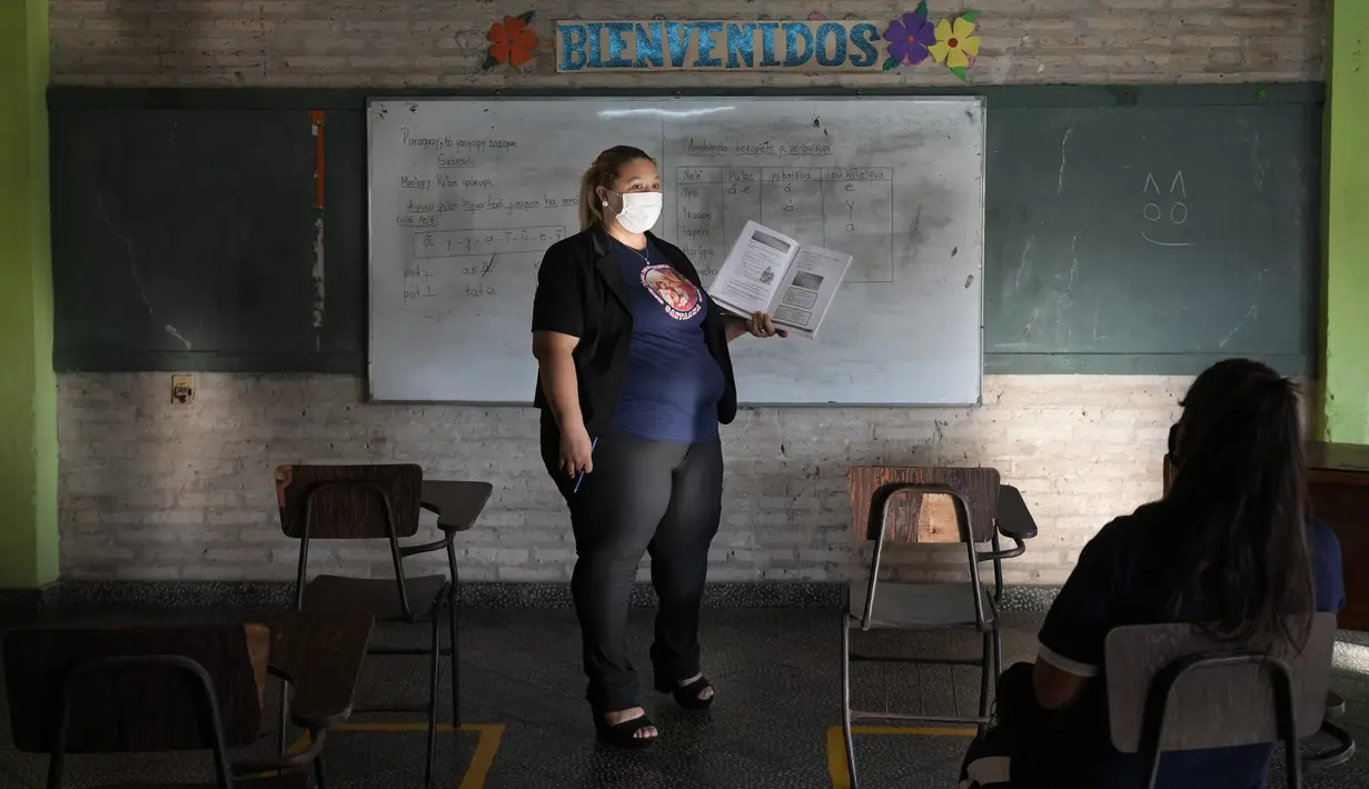 Luz Aranda mengajar kelas bahasa Guarani sekolah tujuh pada hari pertama kelas tatap muka di National School 1044 Santa Ana, Asuncion, Paraguay, Senin (30/8/2021). Sekolah tatap muka digelar setelah satu setengah tahun belajar jarak jauh di tengah pandemi COVID-19. (AP Photo/Jorge Saenz)