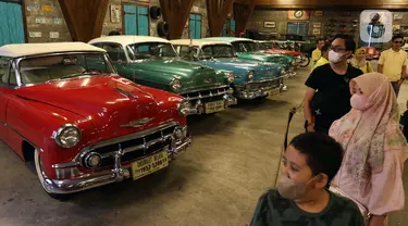 Pengunjung melihat deretan mobil antik di Museum Angkut, Kota Batu, Jawa Timur, Kamis (15/12/2022). Museum Angkut memamerkan koleksi kendaraan antik dari seluruh dunia. (Liputan6.com/Herman Zakharia)