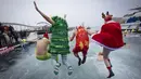Sejumlah peserta berkostum khas hari Natal melompat ke dalam air dalam ajang Copa Nadal yang berlangsung di Barcelona's Port Vell, Barcelona, Kamis (25/12/2025) waktu setempat. Acara tersebut diikuti lebih dari 450 peserta. (AFP/Josep Lago)