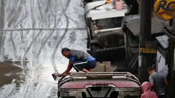 Warga membersihkan abu vulkanik dari kendaraan mereka setelah erupsi Gunung Taal di Tagaytay, Provinsi Cavite, Filipina, Senin (13/1/2020). Gunung yang terakhir meletus pada tahun 1977 tersebut melontarkan abu vulkanik mencapai 50.000 kaki (15.000 meter) ke atmosfer. (AP Photo/Aaron Favila)