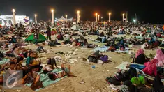 Sejumlah pengunjung tidur usai menyaksikan atraksi kembang api di Pantai Lagoon, Ancol, Jakarta, Minggu (1/1). Warga yang menghabiskan malam tahun baru di kawasan Ancol memilih untuk beristirahat hingga esok pagi. (Liputan6.com/Gempur M. Surya)