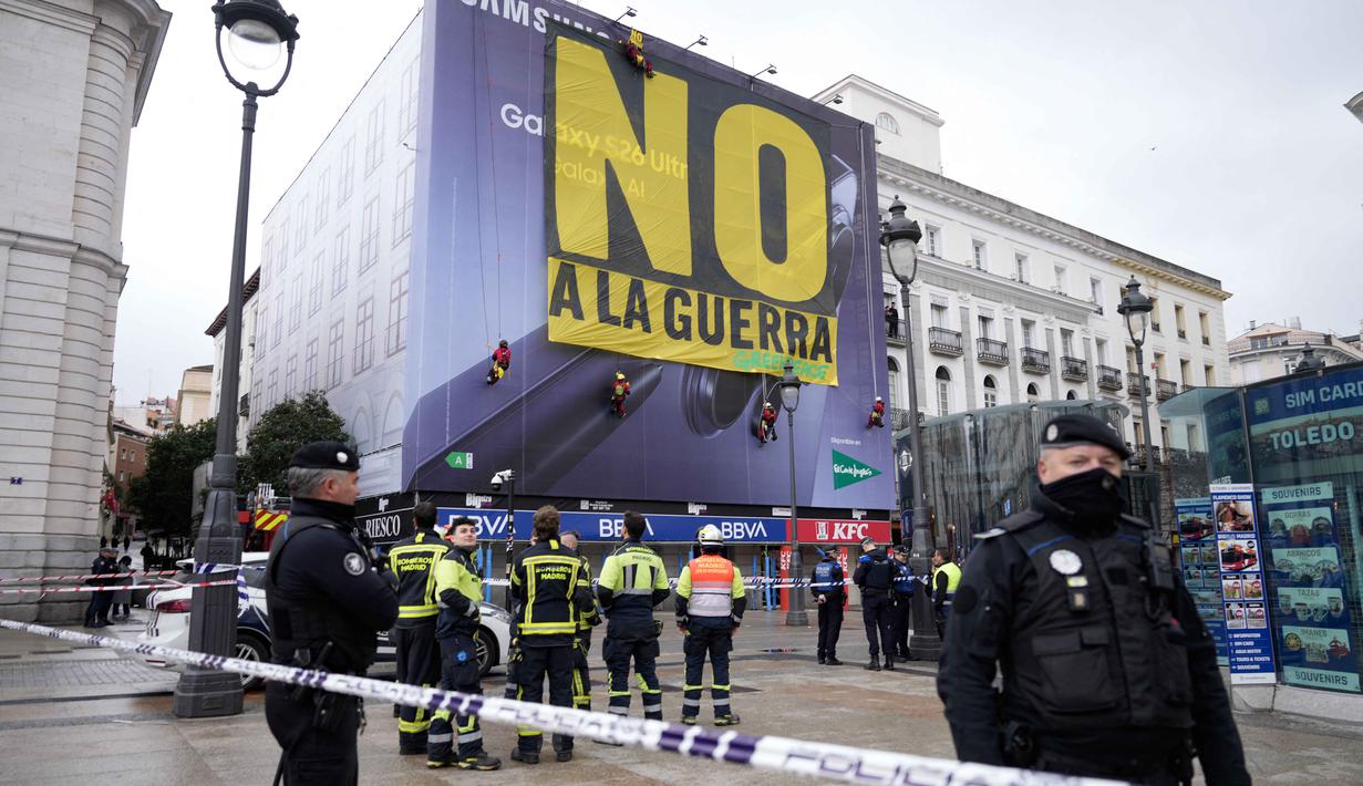 Petugas polisi membentuk perimeter saat aktivis Greenpeace membentangkan spanduk besar bertuliskan "Tidak untuk Perang" sebagai bentuk protes terhadap serangan Amerika Serikat (AS) dan Israel terhadap Iran, di Lapangan Puerta del Sol, Madrid, Spanyol, pada Selasa 10 Maret 2026. Aksi unjuk rasa merespons serangan militer Amerika Serikat dan Israel ke Iran marak terjadi secara global, termasuk di Kota Madrid, Spanyol. (Paul Hanna/AFP)