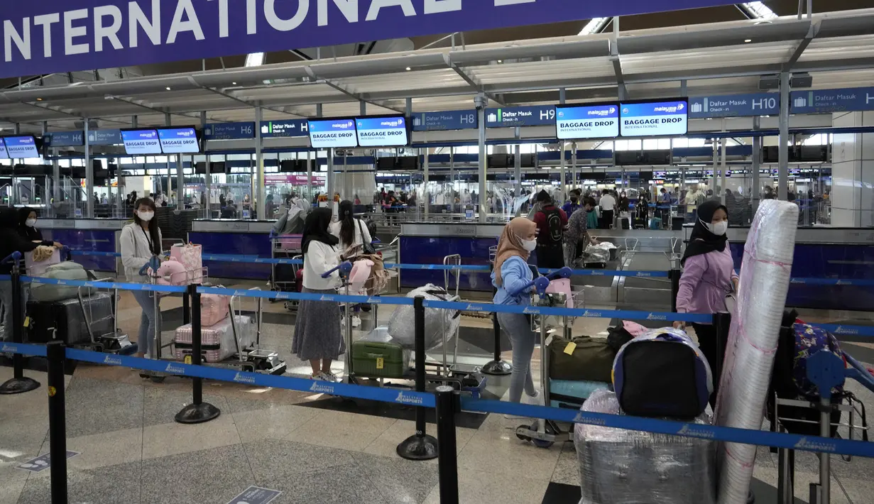 <p>Pelancong mengantre di konter check-in Bandara Internasional Kuala Lumpur, Sepang, Malaysia, Jumat (1/4/2022). Mulai hari ini, Malaysia membuka perbatasannya untuk orang asing dan pelancong yang sudah divaksin COVID-19 lengkap tanpa harus menjalani karantina. (AP Photo/Vincent Thian)</p>